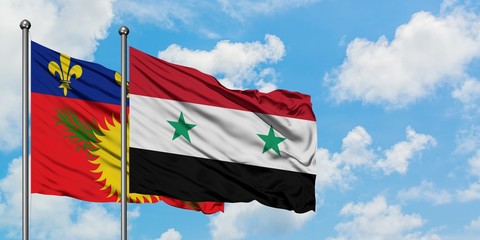 Guadeloupe and Syria flag waving in the wind against white cloudy blue sky together. Diplomacy concept, international relations.