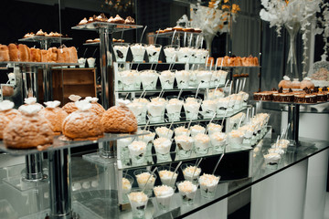 Refrigerated cups of chocolate ice cream. Sweet table on the wedding with delicious desserts. Candy bar. Table with sweet candies. Wedding cake. Dessert table at wedding reception