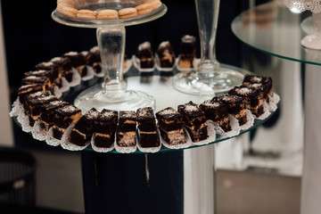 Sweet sliced cakes at white plate. Wedding reception party. Delicious  cake on the buffet table.  Luxury life.  Dessert table at wedding reception