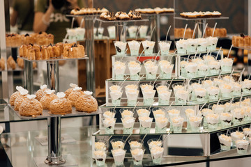 Candy Bar. Birthday table decoration. Candy bar for party. Dessert table for a party. Cake, cupcakes, sweetness. Elegant and luxurious event arrangement.  Luxury life. Delicious sweets on candy buffet