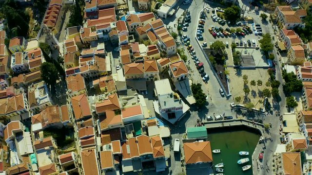 historical picturesque Greek houses of the island of Simi, flying on a drone over city and the Bay with a pier and ships