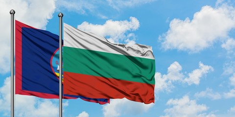 Guam and Bulgaria flag waving in the wind against white cloudy blue sky together. Diplomacy concept, international relations.