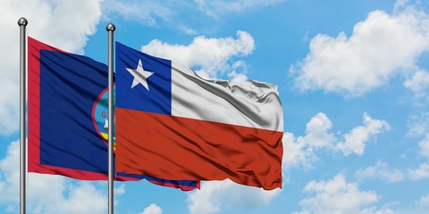 Guam and Chile flag waving in the wind against white cloudy blue sky together. Diplomacy concept, international relations.