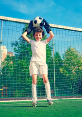 Summer soccer tournament for young kids. football club. emotions and joy of the game. Young goalie. Kids - soccer champion. Boy goalkeeper in football sportswear on stadium with ball. Sport concept.