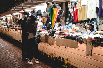 A man chooses and tries on clothes at a flea market.