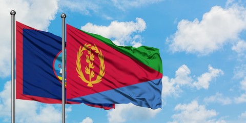 Guam and Eritrea flag waving in the wind against white cloudy blue sky together. Diplomacy concept, international relations.