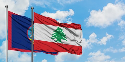 Guam and Lebanon flag waving in the wind against white cloudy blue sky together. Diplomacy concept, international relations.