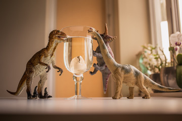 3 dinosaurs amazed with a view of baby dinosaur hatching from an egg