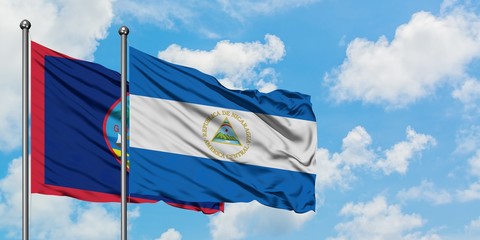 Guam and Nicaragua flag waving in the wind against white cloudy blue sky together. Diplomacy concept, international relations.