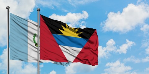 Guatemala and Antigua and Barbuda flag waving in the wind against white cloudy blue sky together. Diplomacy concept, international relations.