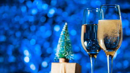 Happy new year and merry Christmas 2020. Two glasses of champagne on a holiday blue background