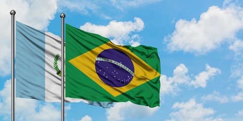 Guatemala and Brazil flag waving in the wind against white cloudy blue sky together. Diplomacy...
