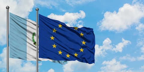 Guatemala and European Union flag waving in the wind against white cloudy blue sky together....