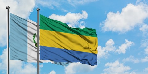 Guatemala and Gabon flag waving in the wind against white cloudy blue sky together. Diplomacy concept, international relations.