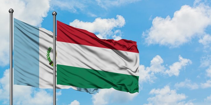 Guatemala and Hungary flag waving in the wind against white cloudy blue sky together. Diplomacy concept, international relations.