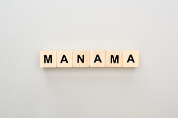 top view of wooden blocks with Manama lettering on grey background