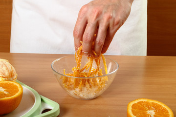 Coating orange peels with sugar. Candied Orange Zest Cooking. Series.