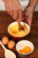 Whisking vigorously to disperse oil. Making Mayonnaise. Series.
