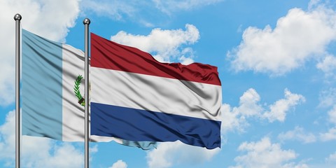 Guatemala and Netherlands flag waving in the wind against white cloudy blue sky together. Diplomacy concept, international relations.