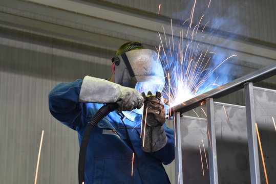 welder works in metal construction - construction and processing of steel components