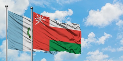 Guatemala and Oman flag waving in the wind against white cloudy blue sky together. Diplomacy concept, international relations.