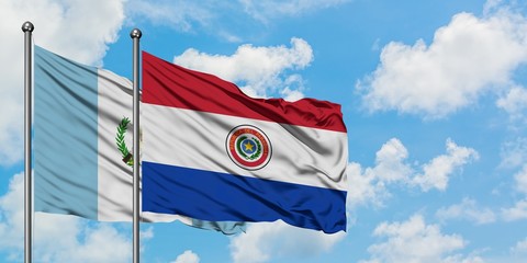 Guatemala and Paraguay flag waving in the wind against white cloudy blue sky together. Diplomacy concept, international relations.