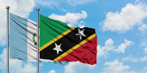 Guatemala and Saint Kitts And Nevis flag waving in the wind against white cloudy blue sky together....