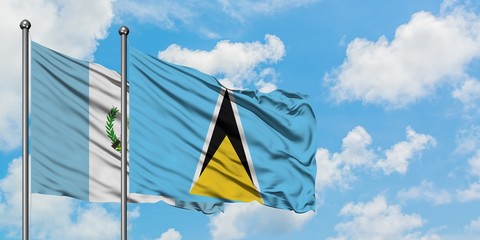 Guatemala and Saint Lucia flag waving in the wind against white cloudy blue sky together. Diplomacy concept, international relations.