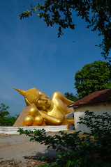 Reclining Buddha gold statue ( Phra Buddhasaiyas ) with blue sky