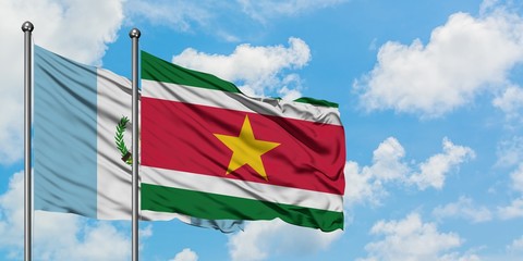 Guatemala and Suriname flag waving in the wind against white cloudy blue sky together. Diplomacy concept, international relations.