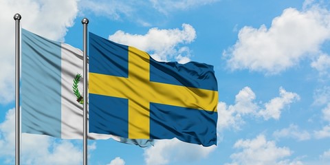 Guatemala and Sweden flag waving in the wind against white cloudy blue sky together. Diplomacy concept, international relations.