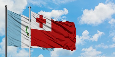 Guatemala and Tonga flag waving in the wind against white cloudy blue sky together. Diplomacy concept, international relations.