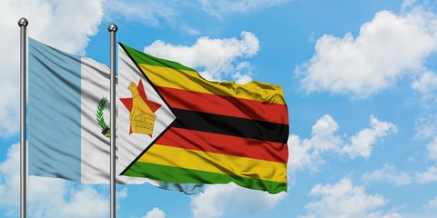 Guatemala and Zimbabwe flag waving in the wind against white cloudy blue sky together. Diplomacy concept, international relations.