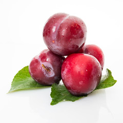 plums with plum leaves isolated on a white background