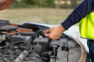 hands of auto mechanic close-up holding a oil gage to check the oil