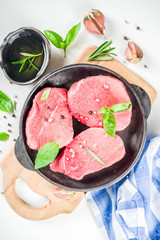 Raw fresh meat. Beef meat steaks with spices and herbs, white background top view copy space