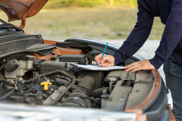 Fototapeta premium Auto car repair service center on the road. A mechanic checking car breaks.