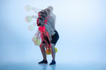 Better. Young caucasian bodybuilder training over studio background in neon and strobe light....