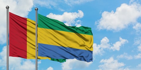 Guinea and Gabon flag waving in the wind against white cloudy blue sky together. Diplomacy concept, international relations.