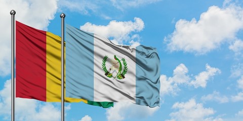 Guinea and Guatemala flag waving in the wind against white cloudy blue sky together. Diplomacy...