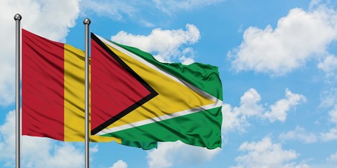 Guinea and Guyana flag waving in the wind against white cloudy blue sky together. Diplomacy concept, international relations.
