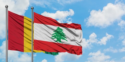 Guinea and Lebanon flag waving in the wind against white cloudy blue sky together. Diplomacy concept, international relations.