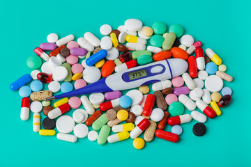 Pills and electronic thermometer (37.5 degrees) - medical background