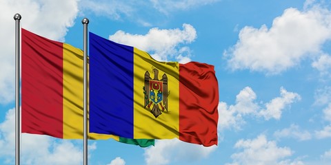 Guinea and Moldova flag waving in the wind against white cloudy blue sky together. Diplomacy concept, international relations.