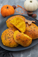 pumpkin buns on dark dish on ceramic background