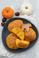 pumpkin buns on dark dish on ceramic background