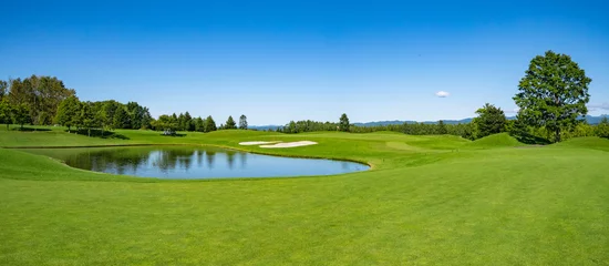 Fotobehang Golfbaan met prachtig groen veld. Golfbaan met een rijke groene grasmat prachtig landschap. © okimo