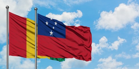 Guinea and Samoa flag waving in the wind against white cloudy blue sky together. Diplomacy concept,...
