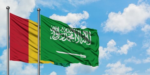Guinea and Saudi Arabia flag waving in the wind against white cloudy blue sky together. Diplomacy concept, international relations.