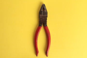old red pliers in colorful background